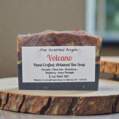Handcrafted artisanal bar soap labeled 'Volcano' by The Scented Angels on a wooden surface.