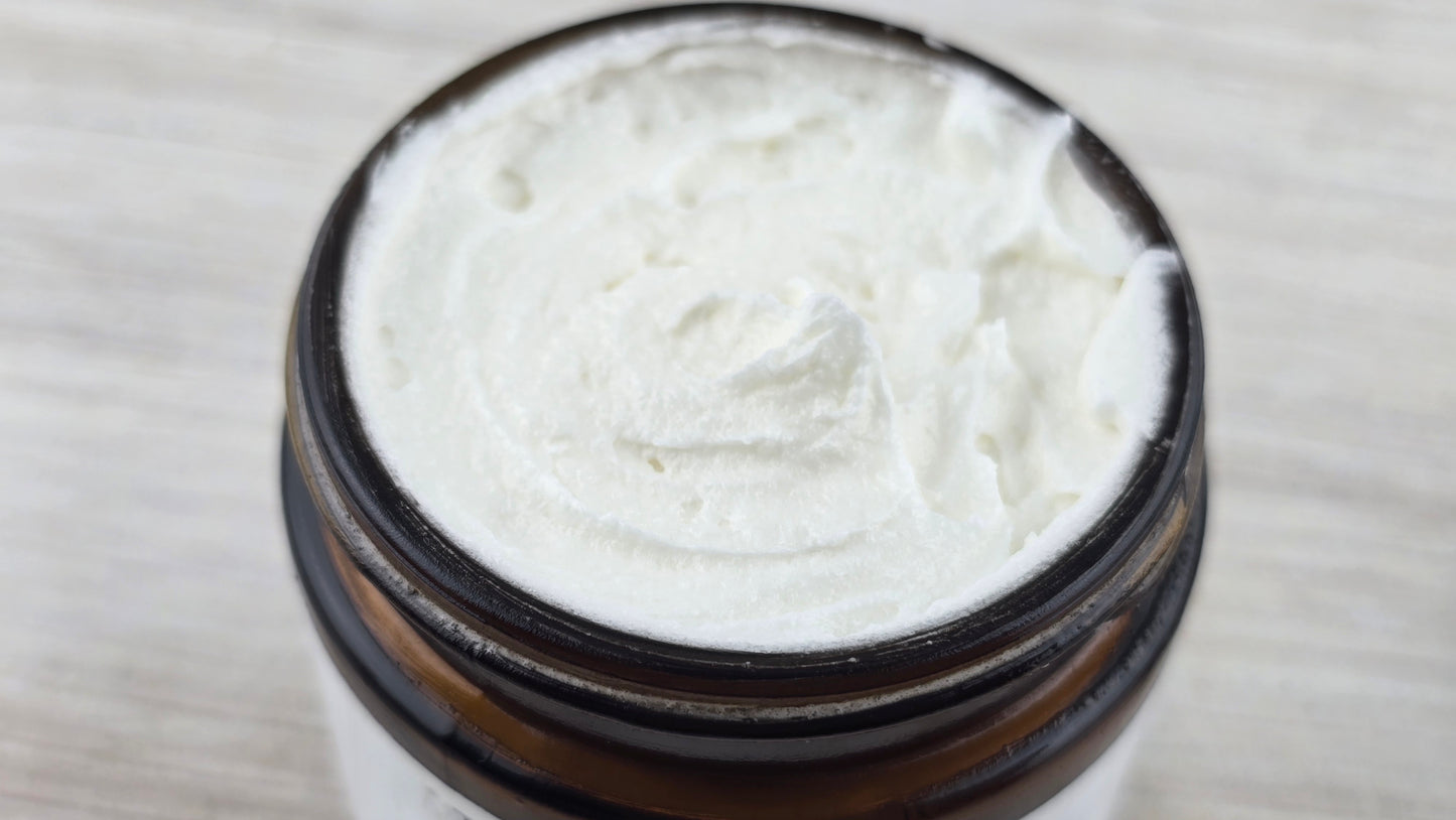 Close-up of a jar with white cream on a light wooden surface.