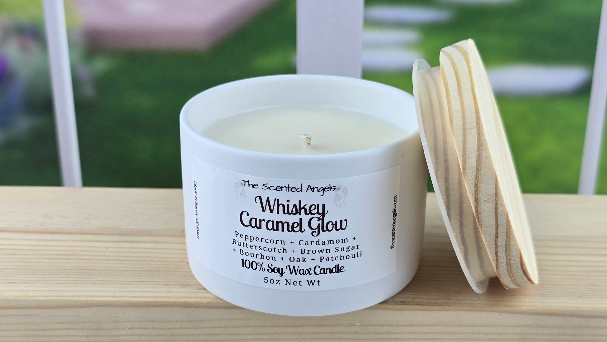 Soy wax candle with a label that reads Whiskey Caramel Glow and a hand-cut pine wood lid