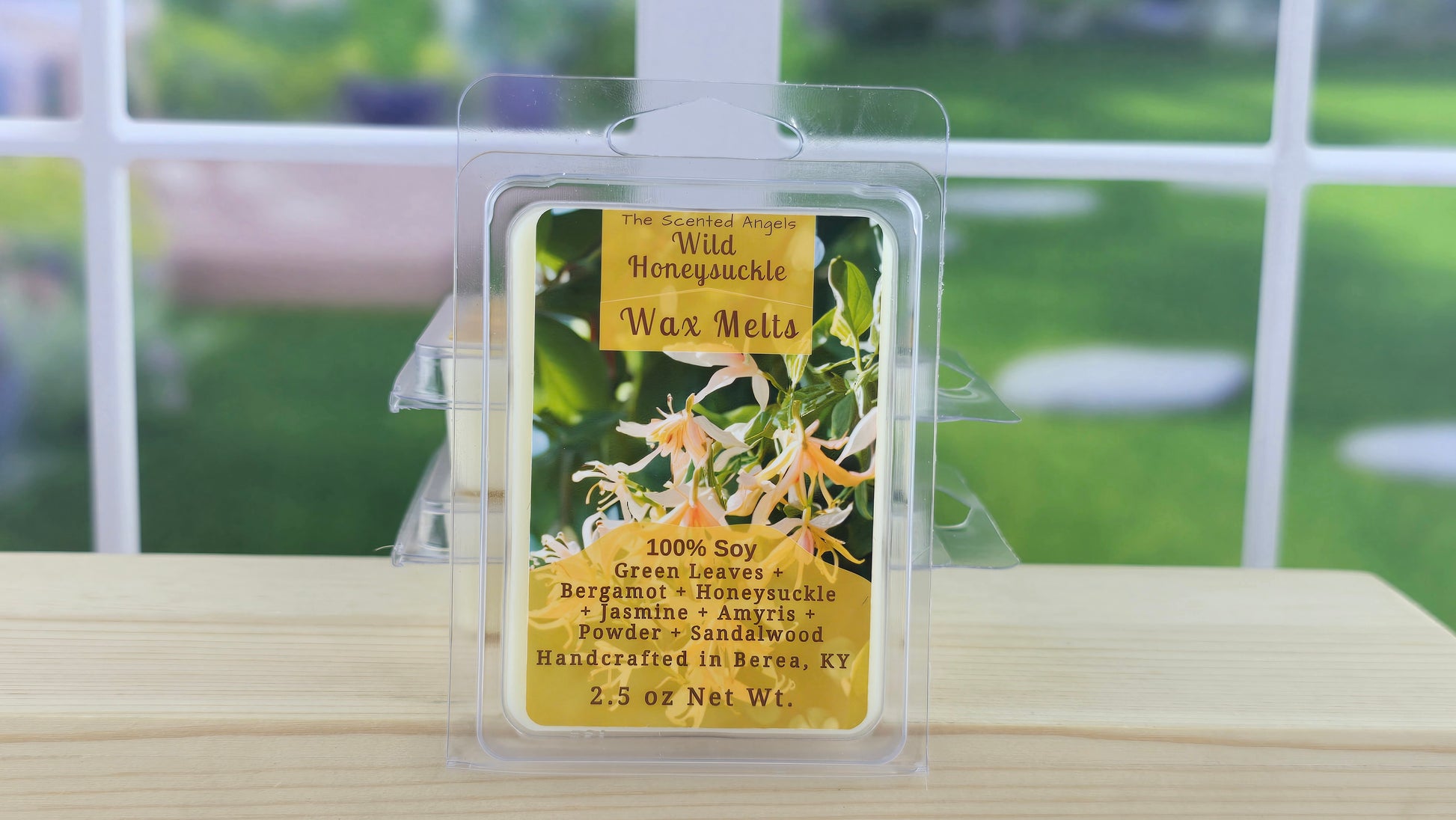 Wax melt packaging with floral design on a wooden surface